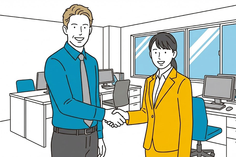 外国人スタッフと日本人担当者が笑顔で握手をしているオフィスの風景